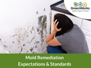 Side view of a woman looking at mold in her kitchen