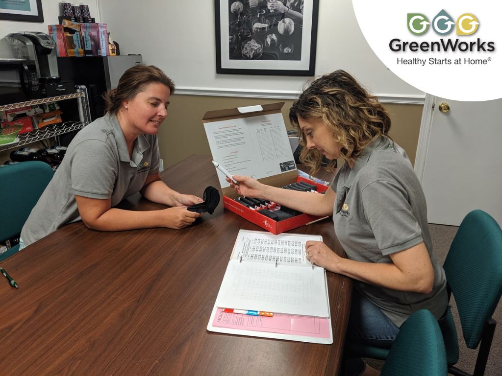 Two indoor air quality professionals reviewing test samples and documentation during an environmental inspection at an office table.