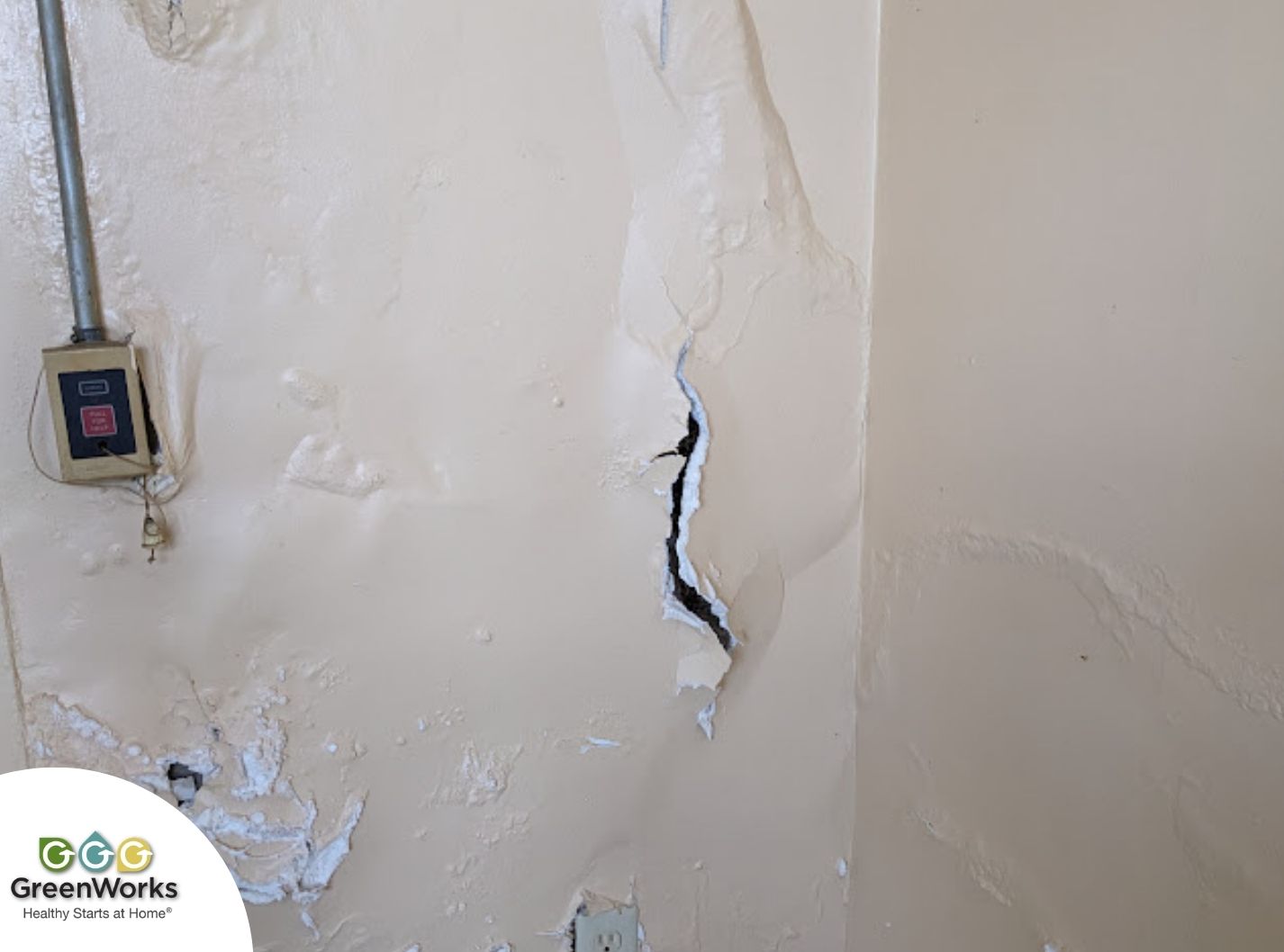 Peeling paint and a crack on a wall indicate moisture damage from condensation.